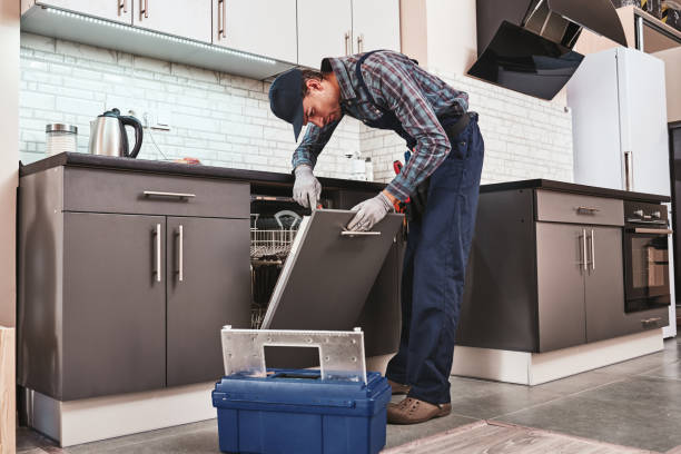 istock Service in time. Male technician sitting near dishwasher 1129117533