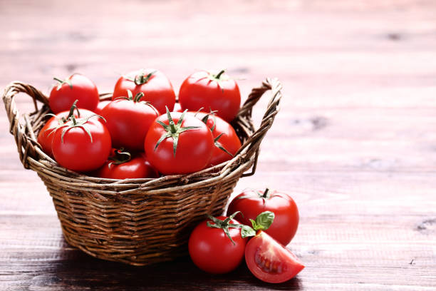 istock Fresh and ripe tomatoes in basket on brown wooden table 1129123151