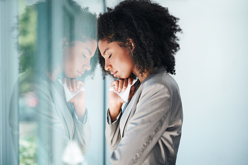 Shot of a young businesswoman looking stressed out in an office