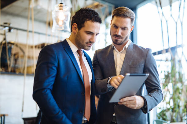 istock Two young businessmen discussing business strategy using digital tablet 1129124309