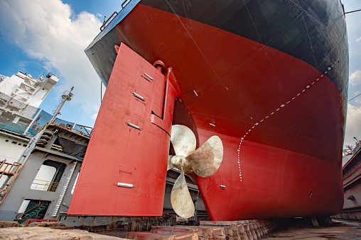 aft of the commercial ocean ship in floating dry dock yard, completed recondition painting over hull cleaning in dock yard terminal, ready to delivery to the sea services