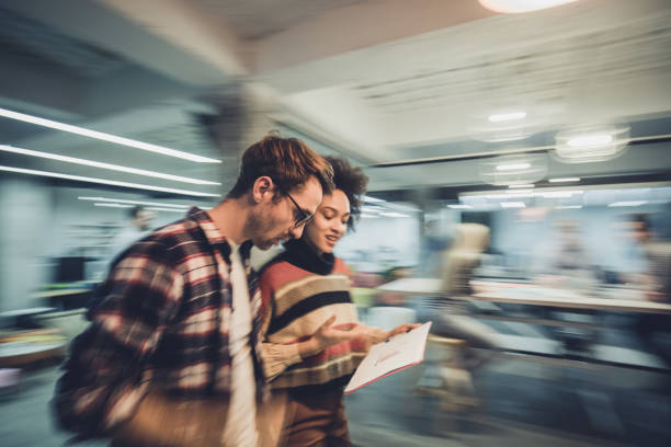 Blurred motion of young entrepreneurs reading reports in the office.
