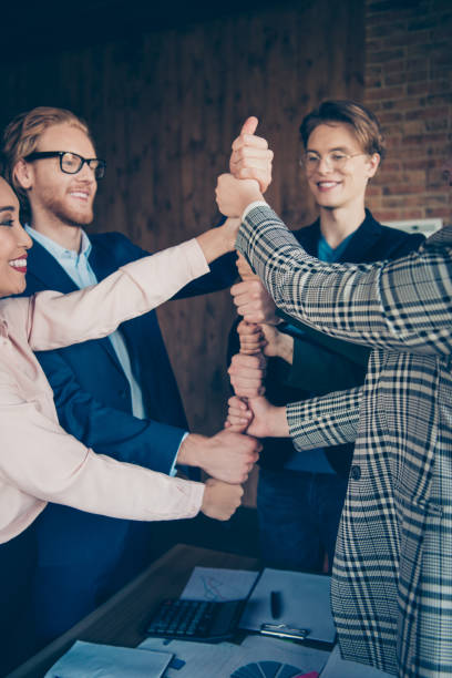 istock Vertical of nice chic elegant attractive beautiful clever smart intelligent sharks experts specialists putting fists on each other at modern industrial loft interior work place station 1129129219