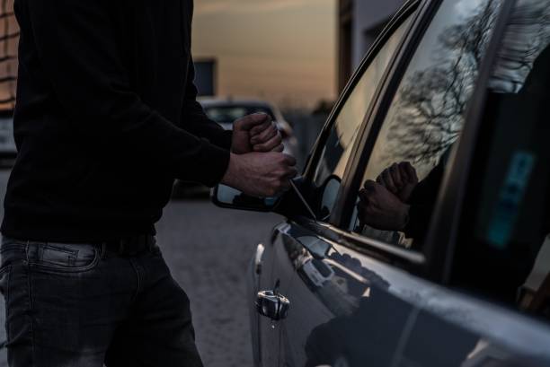 istock Car thief opening stolen car doors 1129129331