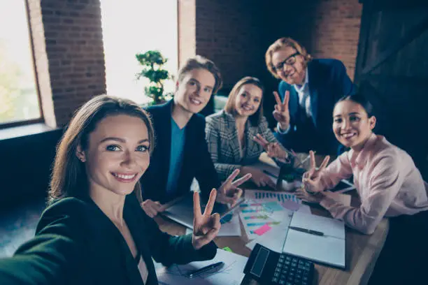 Photo of Self-portrait of nice chic beautiful attractive stylish trendy dreamy elegant cheerful cheery bankers specialists showing v-sign at modern industrial loft interior work place station