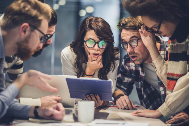 istock Team of shocked freelance workers reading business reports in the office. 1129130992