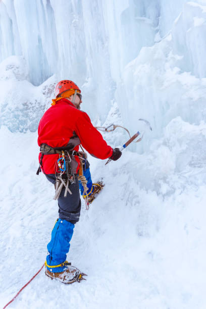 istock climber doing steps in the ice with an ice ax 1129131062