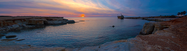 Extra wide panorama of beautiful seascape and shipwreck. Abandoned ship Edro III at sunset near the Paphos, Cyprus.