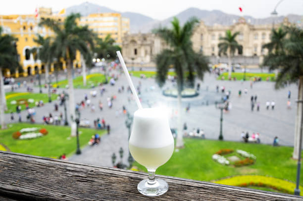 Pisco sour homemade cocktail with the background of the main square of Lima stock photo
