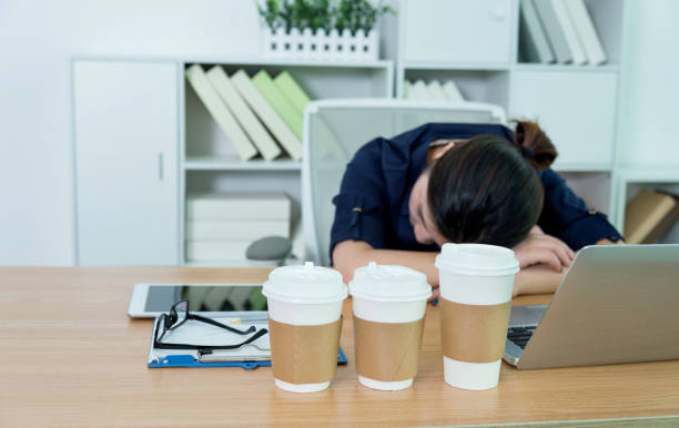 istock Tired businesswoman sleeping on desk 1129137245