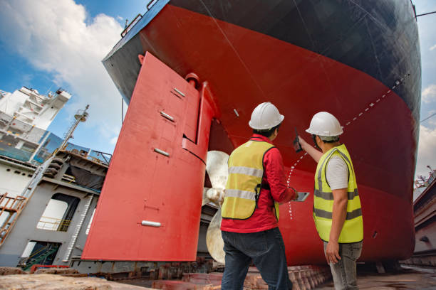 Last review inspector, port controler, surveyor, foreman inspecting the final repairing of painting cleaning over hull dry dock of the commercial ocean tannage ship, checking detail and report on line the progress of works propeller photos stock pictures, royalty-free photos & images