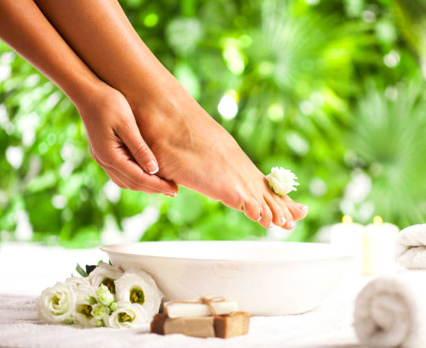 spa para os pés em um fundo de folhas verdes tropicais - manicure pedicure human foot french culture - fotografias e filmes do acervo