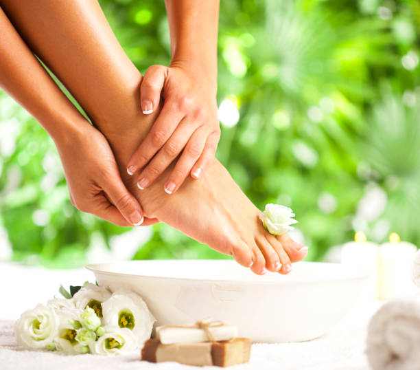 spa para os pés em um fundo de folhas verdes tropicais - manicure pedicure human foot french culture - fotografias e filmes do acervo