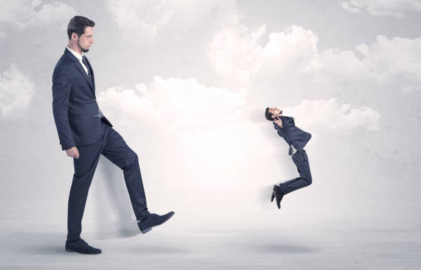 istock Big boss kicking little employee 1129139818