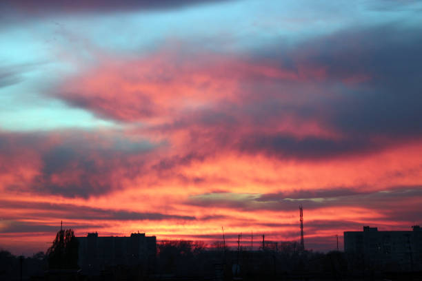 istock Crimson sunset above multistory house. Evening cityscape 1129139885