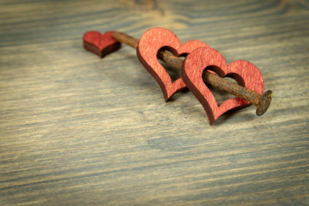istock Wooden hearts and rusted nail on rustic background 1129141452