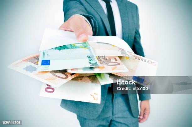 Man Giving An Envelope Full Of Euro Bills Stock Photo - Download Image Now - Currency, European Union Currency, Giving
