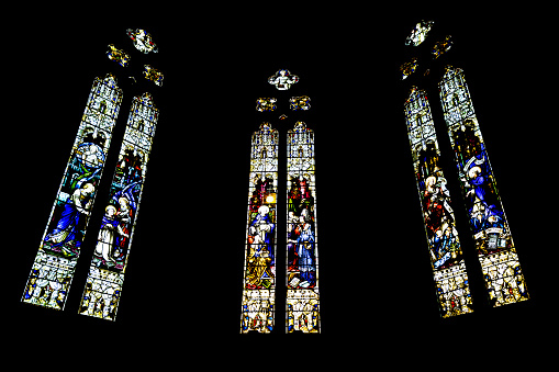 Triptych of stained-glass windows from St Patrick's Cathedral on black background in Melbourne Victoria Australia