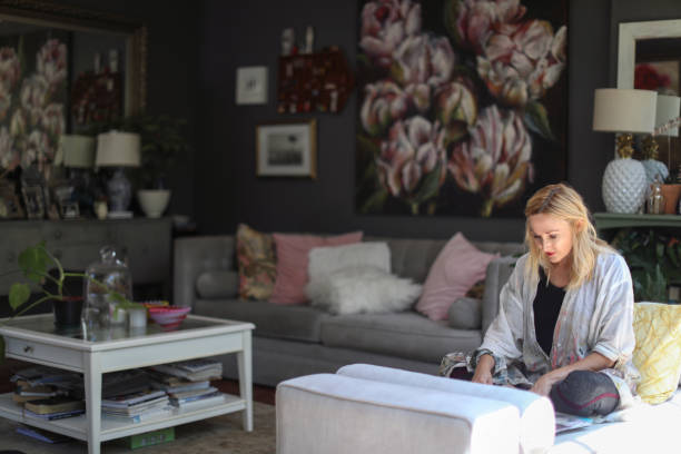 istock a Mature woman sketching on her sofa at home. 1129148519