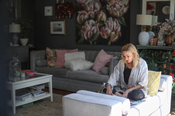 istock a Mature woman sketching on her sofa at home. 1129148549