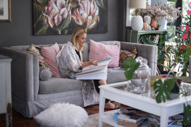 istock a Mature woman sketching on her sofa at home. 1129148800