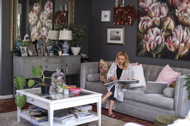 a Mature woman sketching on her sofa at home.
