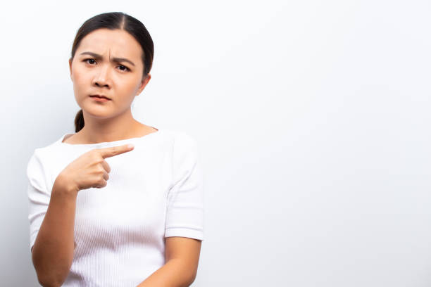 istock Angry woman standing isolated over white background 1129148962