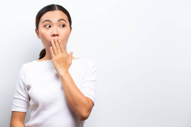 istock Happy woman has surprised and pointing to copy space isolated over white background 1129149242
