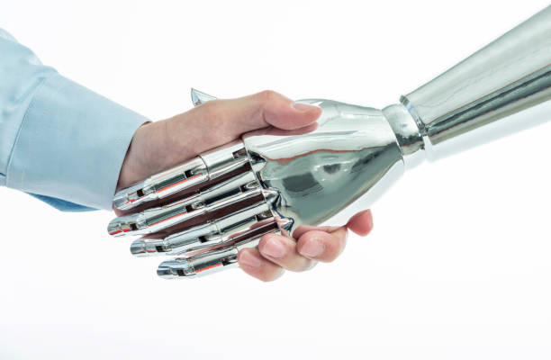 istock Businessman and robot shaking hands on white background 1129149355