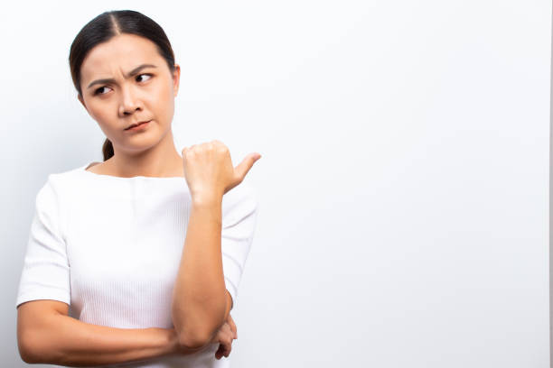 istock Angry woman standing isolated over white background 1129149491