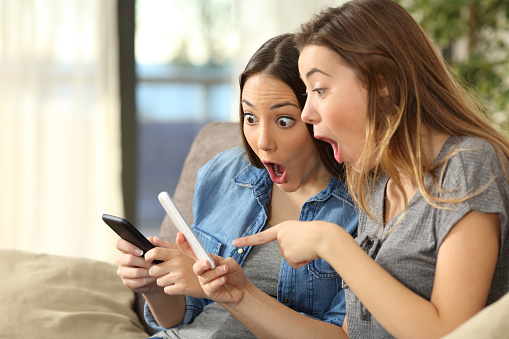 Amazed women finding surprising content on phones