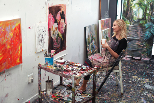 a Mature woman, working on paintings in her home studio.