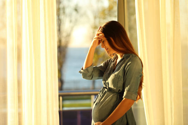 Worried pregnant woman complaining at home Worried pregnant woman complaining at home unwanted pregnancy stock pictures, royalty-free photos & images