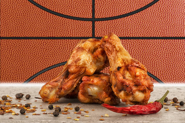 alitas de pollo con imagen de pelota de baloncesto en el fondo. - vegetable basket fotografías e imágenes de stock