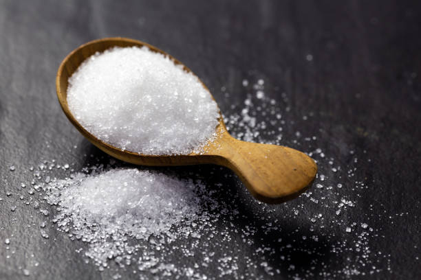 istock Sugar on a wooden spoon On a black background 1129154039