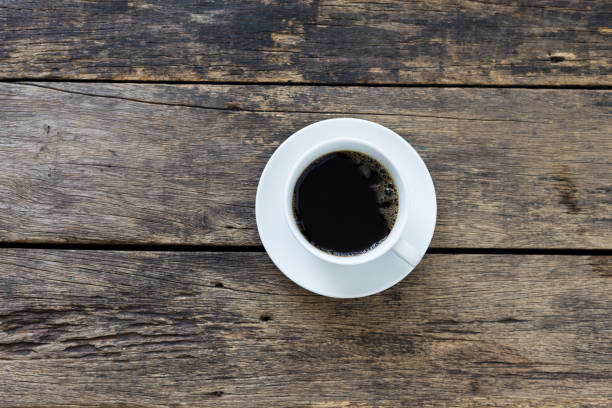 istock coffee cup on wooden table top view 1129154088