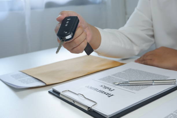 istock colse-up hand giving a car key after signing a document. 1129155185