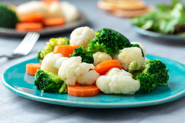 brócoli al vapor, coliflor y zanahorias. - cauliflower vegetable white isolated fotografías e imágenes de stock