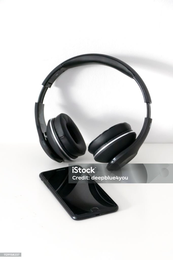 Bluetooth headphones and smartphone on white Cut Out Stock Photo