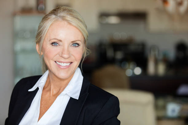Close up of a mature lawyer smiling Close up of a mature lawyer smiling. She is calm, standing on a coffee shop older blonde woman stock pictures, royalty-free photos & images