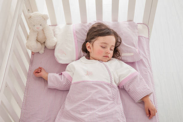 istock cute little girl sleeping in her bed 1129162178