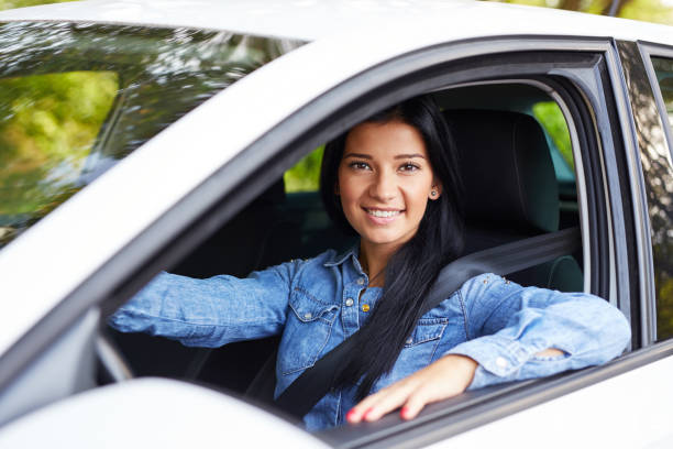 istock Smiling woman driving her car 1129162292