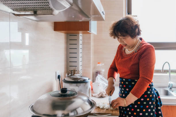 istock chinese grandmother carving vegetables in kitchen 1129162335