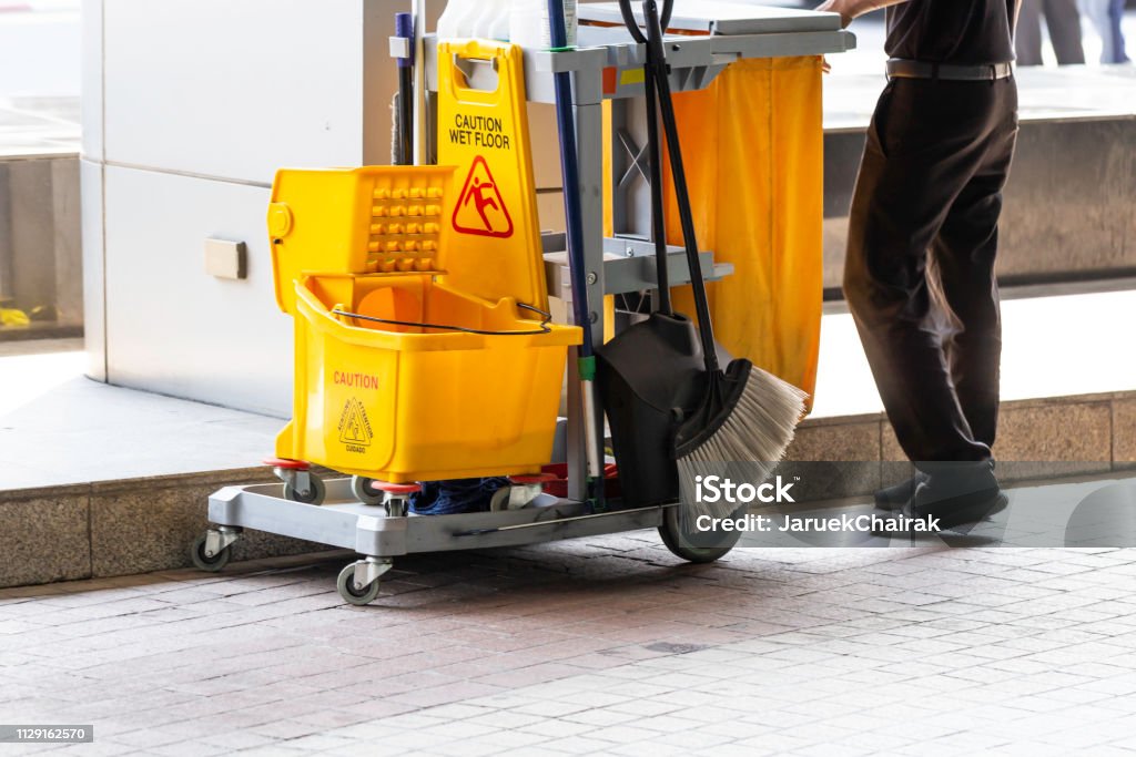 Balde de zeladoria e espanador na limpeza no processo e trabalhador no trabalho. - Foto de stock de Balde royalty-free