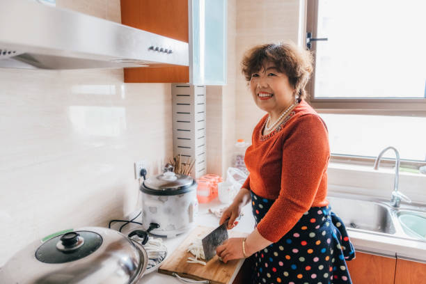istock chinese grandmother carving vegetables in kitchen 1129163831