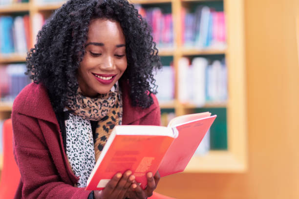 istock Woman reading in the library 1129164101