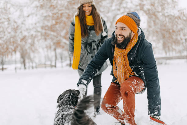 istock Couple in the snow play with dog 1129164194