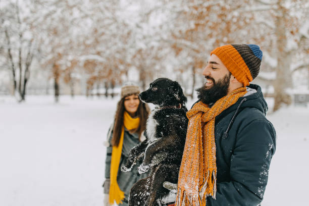 istock Couple in the snow play with dog 1129164416