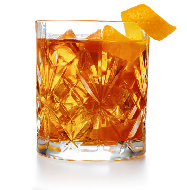 close up of old-fashioned cocktail old fashioned cocktail garnished with orange twist peel isolated cocktails stock pictures, royalty-free photos & images