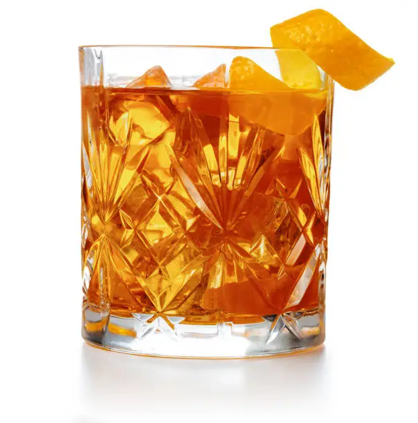 old fashioned cocktail garnished with orange twist peel isolated